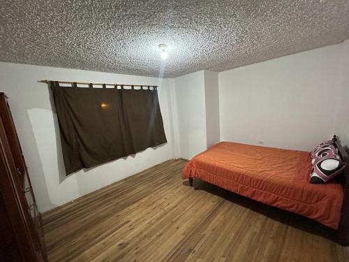 昆卡Casa Terra的一间卧室设有一张床和一个窗口