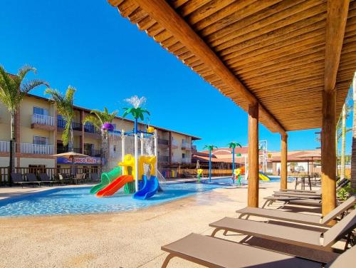 塞古罗港Ondas Praia Resort - MC的游泳池设有1个带滑梯和椅子的游乐场