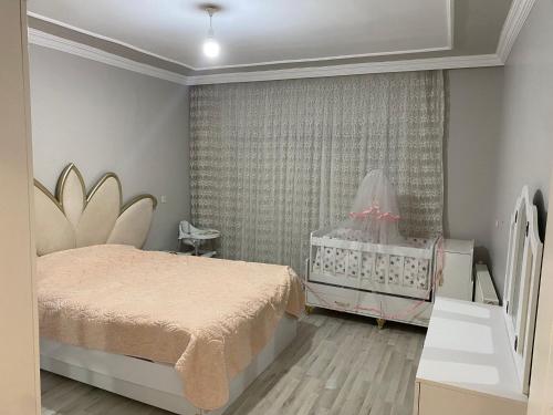 CizreLuxury Flat / Lux Daire Cizre的一间卧室配有一张床和一张婴儿床。