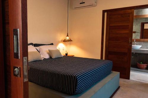 圣米格尔-杜戈斯托苏Vila de Charme的一间卧室设有一张床和一间浴室。