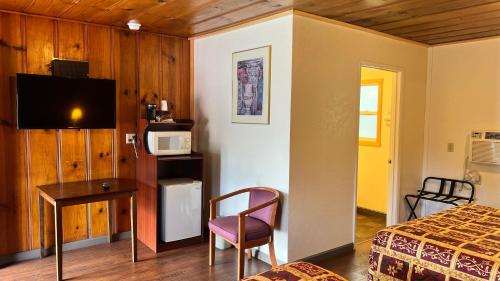 威利茨松塔汽车旅馆的一间卧室配有一张床、一张书桌和一台微波炉
