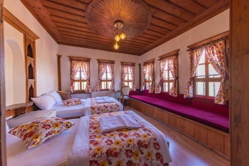 番红花城Cesmeli Konak Garden的一间卧室设有两张床、窗户和吊灯。