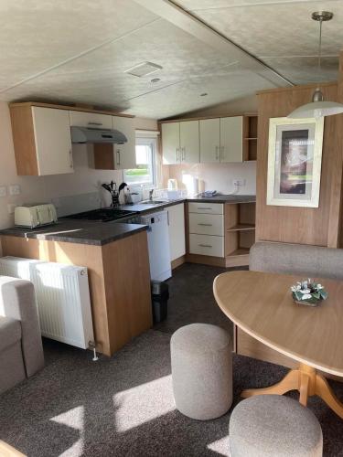 大雅茅斯Holiday home at Parkdean Cherry Tree Holiday Park 627的厨房以及带桌椅的用餐室。