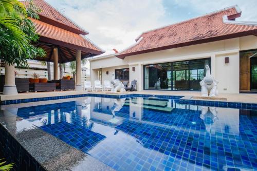 拉威海滩Lotus Pool Villa的一座带游泳池和房子的别墅