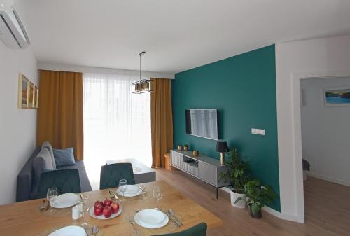 托伦Apartament nr15 z parkingiem podziemnym的客厅配有桌子和蓝色的墙壁