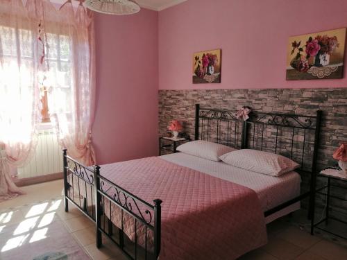 蒂沃利Il Tempietto di Venere的一间卧室配有一张粉红色墙壁的床
