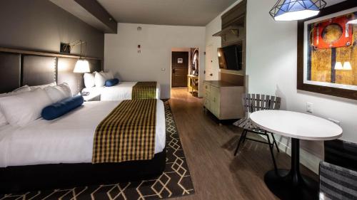 哈蒂斯堡Hotel Indigo Hattiesburg, an IHG Hotel的酒店客房设有两张床和一张桌子。