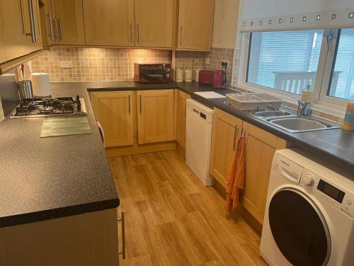 基尔赛斯Lanarkshire entire house sleeps 6, contractors, trade stays的厨房配有水槽和炉灶 顶部烤箱