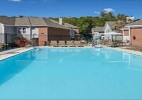切斯特菲尔德圣路易斯切斯特菲尔德希尔顿霍姆伍德套房酒店的一座大蓝色游泳池,位于房子前
