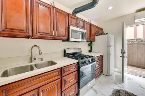 安纳海姆Anaheim Hills Retreat - 17 Mi to Disneyland!的厨房配有木制橱柜、水槽和炉灶。