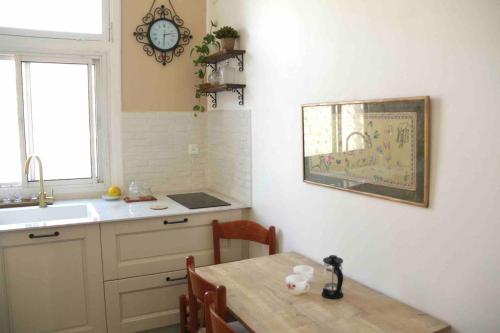 海法Lily’s house的厨房配有桌子、水槽和时钟