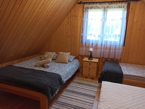 扎莫希奇Agroturystyka Uroki Roztocza的一间卧室设有两张单人床和一个窗户。