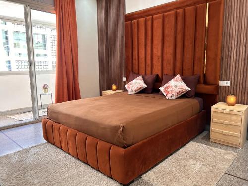 拉巴特Appartement la gare Rabat ville的一间卧室配有一张大床和大型木制床头板