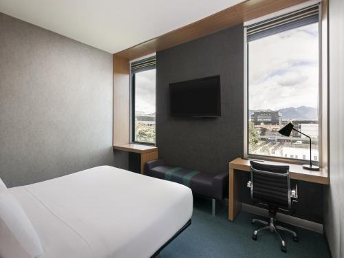 波哥大雅乐轩波哥大机场酒店的酒店客房设有一张床、一张书桌和窗户。