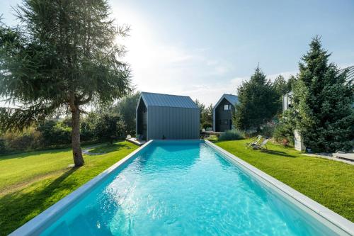 尤斯托尼莫斯基SKARPA resort的一座带棚屋的庭院内的游泳池