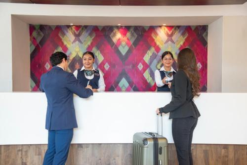 危地马拉危地马拉克拉丽奥套房酒店的一群人站在柜台旁,与一名妇女在一起