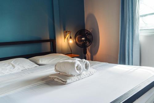 埃尔巴列德安通Bodhi Hostel & Lounge的一间卧室配有两张床、毛巾和风扇