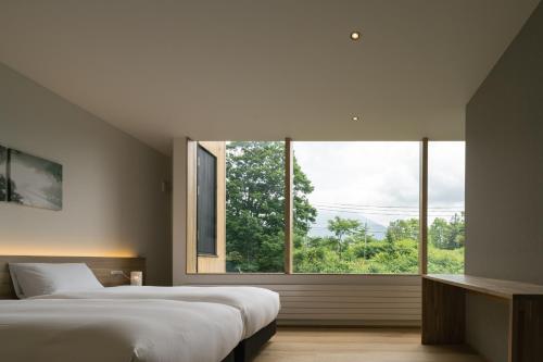 二世古Miru Niseko的一间卧室设有两张床和大窗户