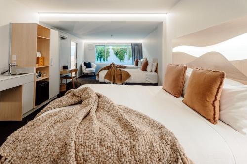 陶朗加CitySide Hotel Tauranga的一间卧室设有两张床和盥洗盆