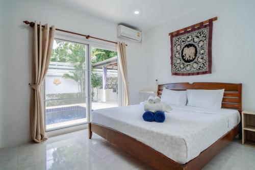 拉威海滩Jasmine Pool Villa in Nai Harn的一间卧室设有一张床和一个大窗户