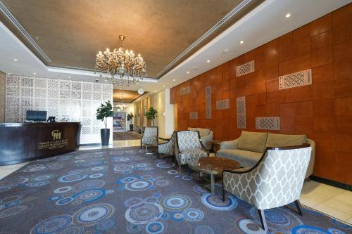 科威特科威特宏伟大酒店的大堂设有带椅子和吊灯的等候区