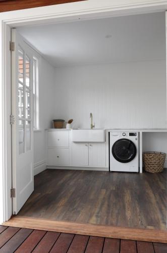 邓斯伯勒Yallingup Homestead的白色的厨房配有水槽和洗衣机