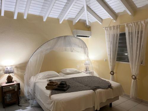 Oyster PondVilla CECILIA的一间卧室配有一张白色天蓬床