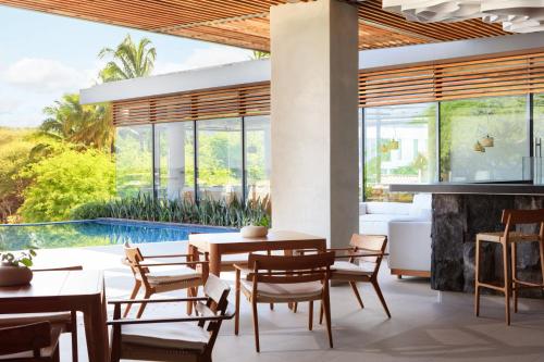 巴克里索莫雷诺港Hotel Indigo - Galapagos, an IHG Hotel的带壁炉的用餐室和游泳池