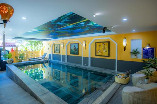 会安Hoianan Boutique Hotel的天花板上画着画的房屋内的游泳池