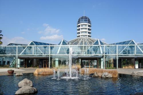 西归浦市Hotel The Grang Jungmun的一座玻璃建筑,前面有一个喷泉