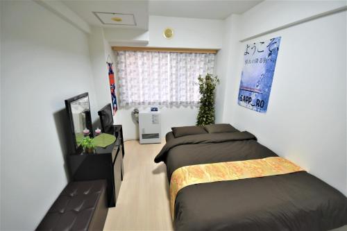札幌Carid Shiraishi In front of the station / Vacation STAY 6173的一间卧室配有两张床和电视。
