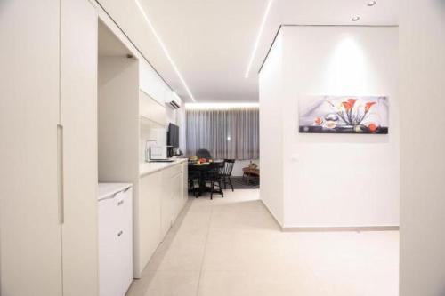 特拉维夫Cozy Apartment in the Heart of Tel Aviv Sea N' Rent的一间厨房,配有白色橱柜和一间餐厅