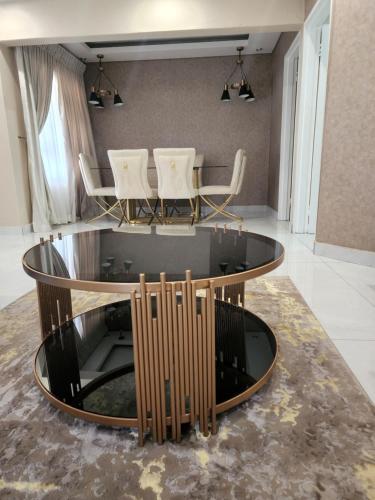 哈博罗内Josmot Guest House的客厅配有圆形桌子和椅子
