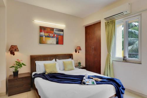莫尔穆冈Veeraas Calangute - 2BHK Apartment with Pool的一间卧室设有一张大床和一个窗户。