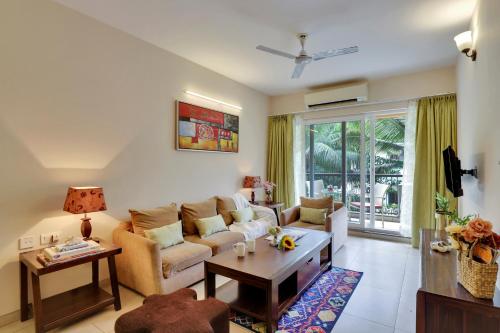 莫尔穆冈Veeraas Calangute - 2BHK Apartment with Pool的客厅配有沙发和桌子