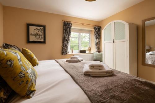 CossingtonCossington Park Cottage的一间卧室配有一张大床和毛巾