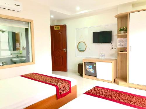 下龙湾Sail Hotel Hạ Long的一间带床和电视的客厅