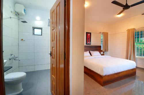 伊都基10 Degrees North By Avni Holidays的一间卧室设有一张床、淋浴和卫生间