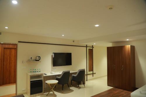 海得拉巴Grand Manor Suites的客厅配有桌椅和电视。