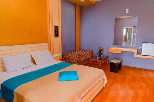 埃尔加德Hotel JK Grand的一间卧室配有一张床、一把椅子和电视