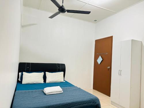 斗湖Macagawa Homestay的一间卧室配有一张蓝色的床和吊扇