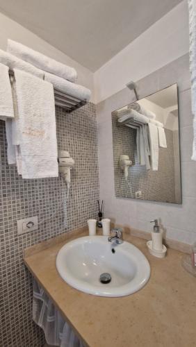 滨海波利尼亚诺La dimora di Poseidone的浴室配有盥洗盆、镜子和毛巾