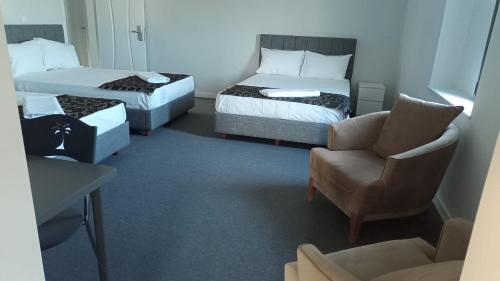 AksuRED FLAG HOTEL的酒店客房,配有两张床和椅子