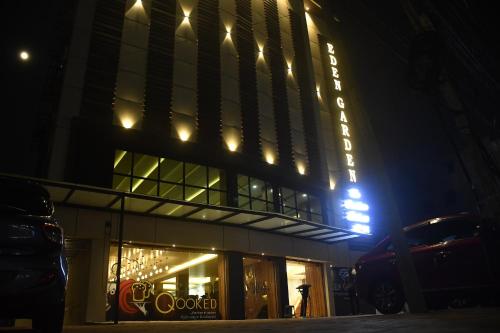 ĀsansolHOTEL EDEN GARDEN的一座晚上有标志的建筑