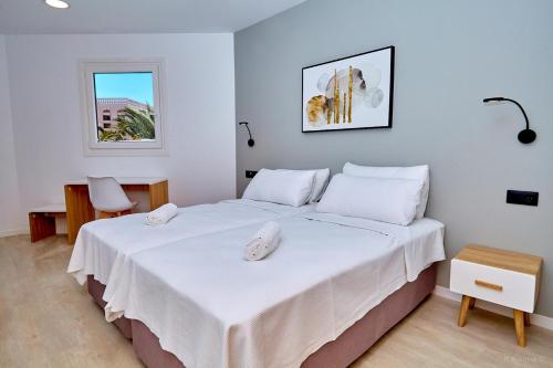 美洲海滩ALEGRIA Barranco的一间卧室配有一张带白色床单的床和一扇窗户。