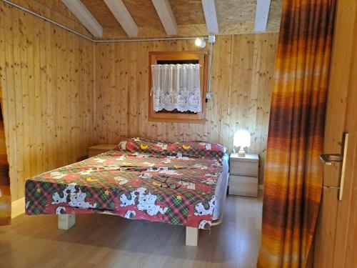 RevòLa quiete di Tregiovo - CIPAT 22253-AT-34903的木制客房内的一间卧室,配有一张床