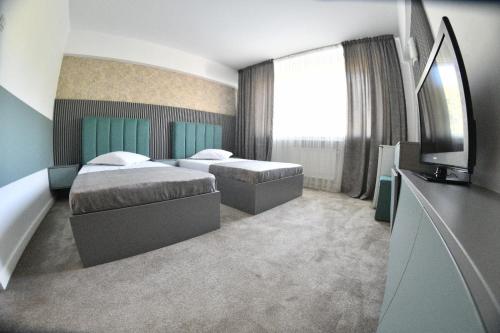 克拉约瓦派克酒店的酒店客房设有两张床和电视。