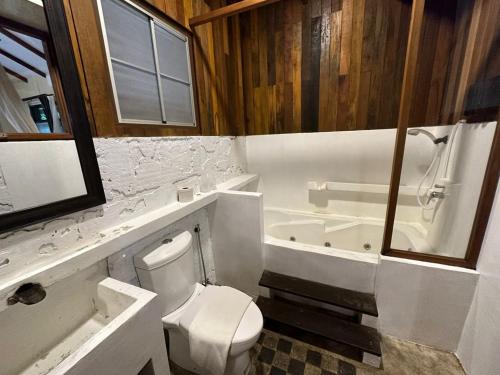 西必洛西必洛森林边缘度假村的浴室配有卫生间、浴缸和水槽。