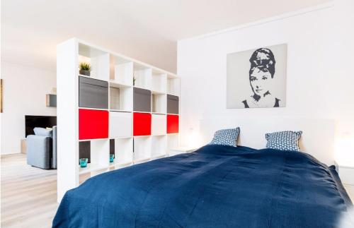 杜塞尔多夫Homefy Altstadt Apartment für 6 Personen, mit 2 Bädern und Balkon的一间卧室配有蓝色的床和白色的架子