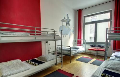 柏林柏林市中心金色旅馆的客房设有两张双层床和红色的墙壁。